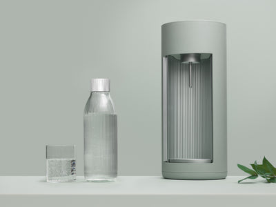 A pigeon Glassy sparkling water maker and glass bottle in front of pigeon background